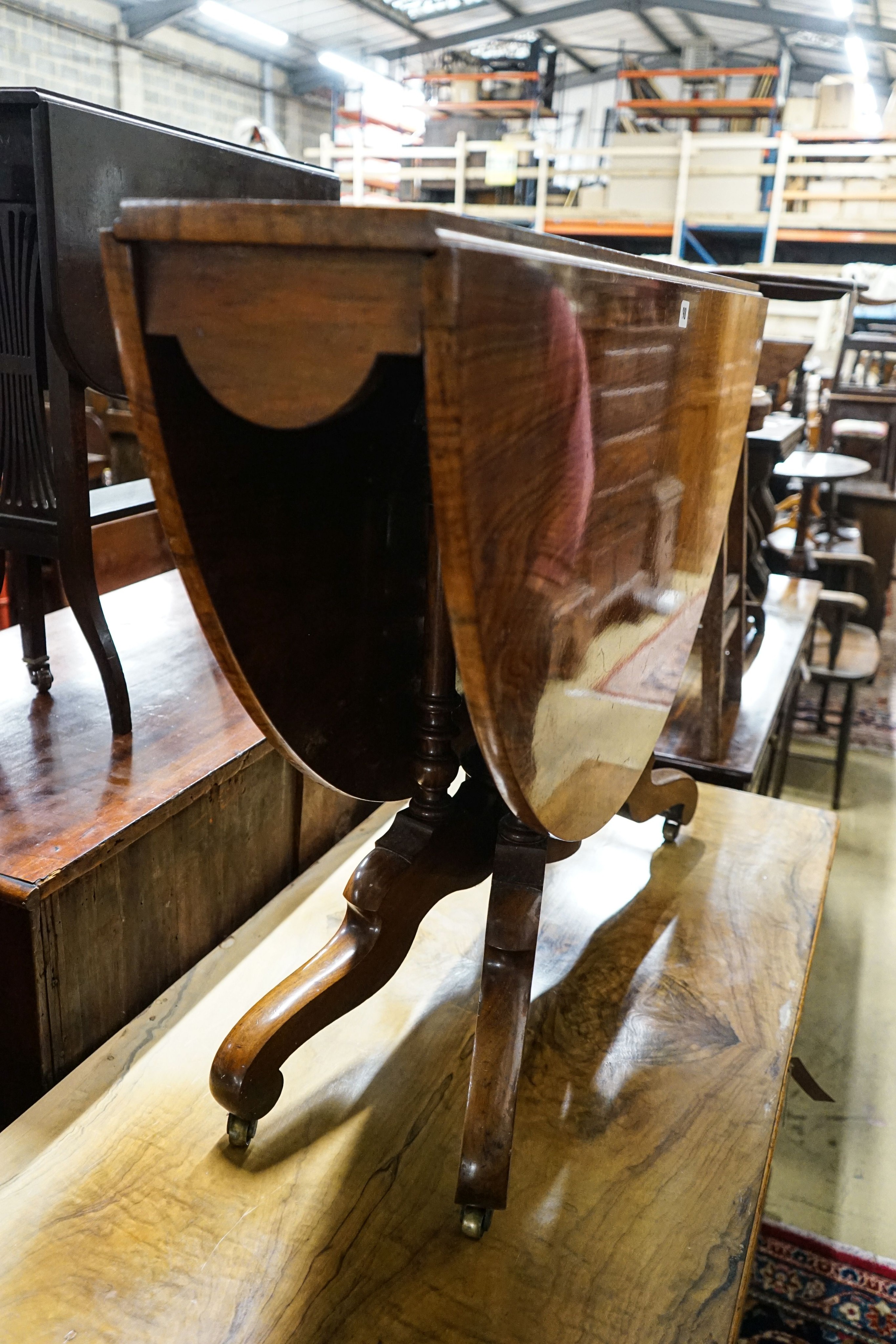 A Victorian figured walnut oval Sutherland table on turned supports and quadripartite scrolled legs, 118cm extended, width 100cm, height 73cm